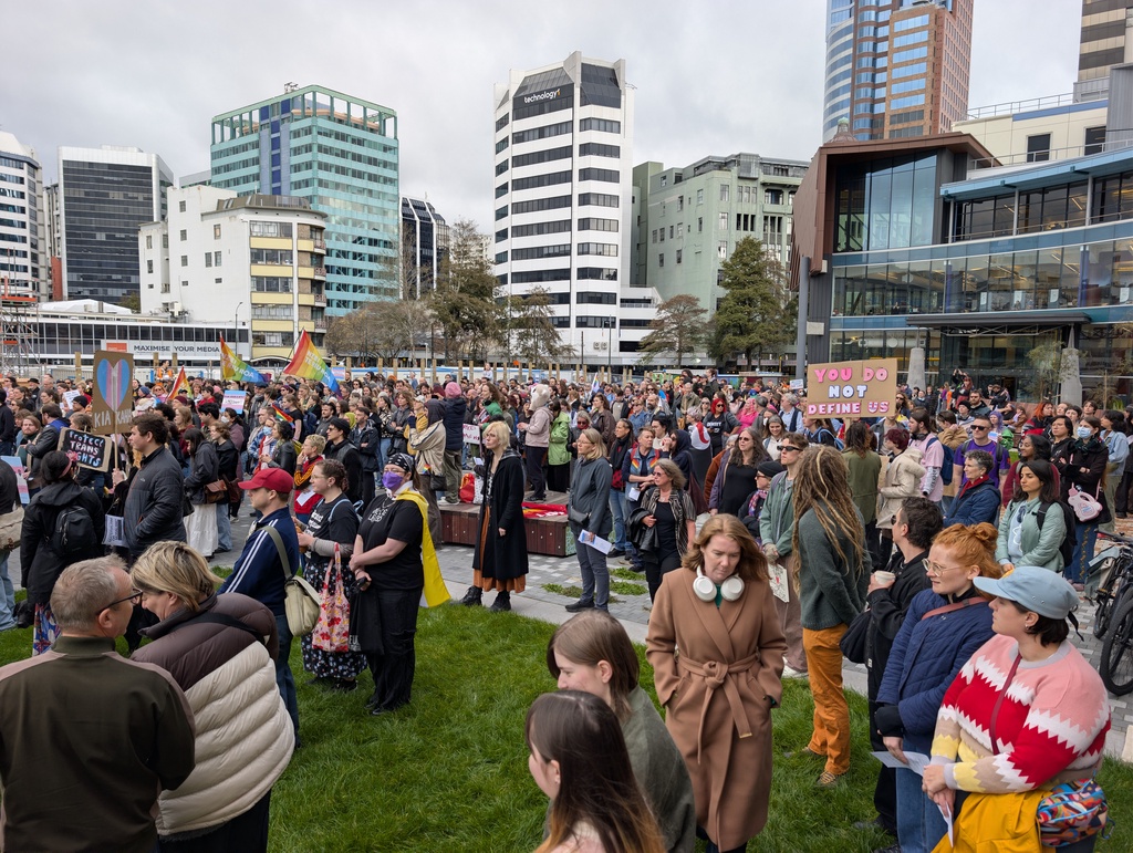 A large crowd of people gathered in an urban plaza.
