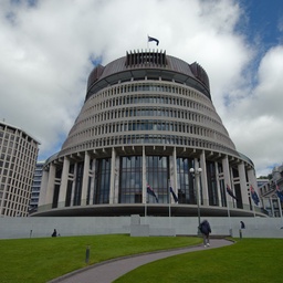 The modern, curved architecture of the building stands against a dramatic sky.