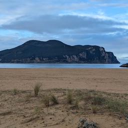A serene beach with a mountainous headland