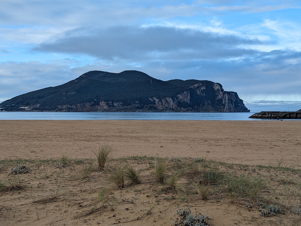 A serene beach with a mountainous headland
