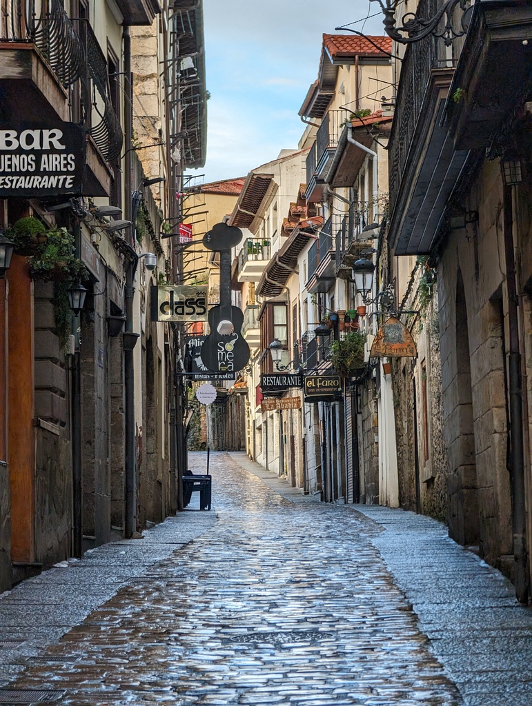 A narrow cobblestone street lined with buildings a
