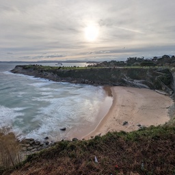 A coastal landscape with a sandy beach, crashing w