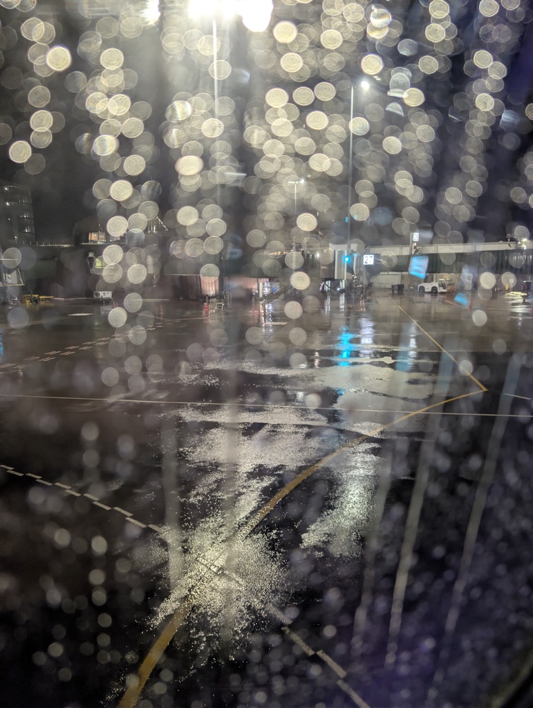 An out-of-focus, wet asphalt road at night.