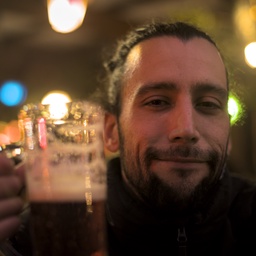 A man holding a large mug of amber beer.