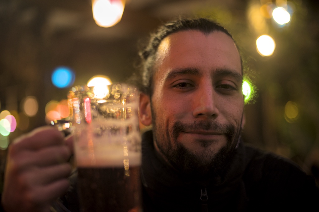 A man holding a large mug of amber beer.