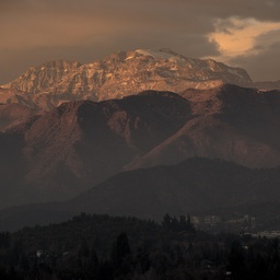 Snowy mountain peaks under a dusky sky.