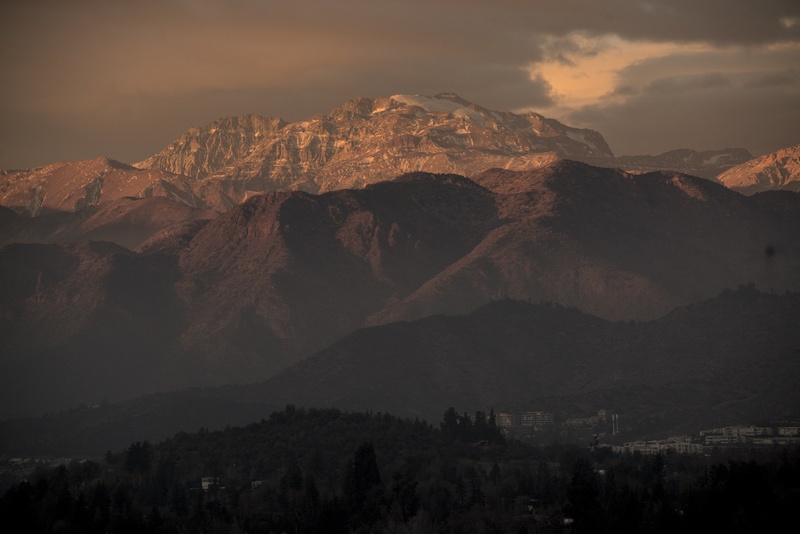 Snowy mountain peaks under a dusky sky.