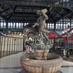 A stone fountain in an indoor marketplace.