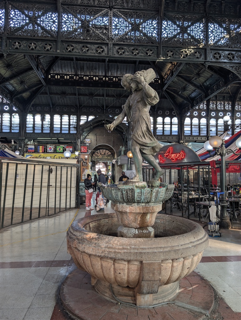 A stone fountain in an indoor marketplace.