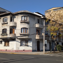 An old, multi-story building on a street corner.