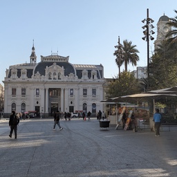 An ornate, white building facing a wide pedestrian plaza.