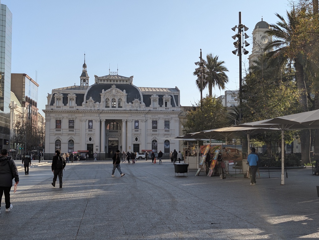 An ornate, white building facing a wide pedestrian plaza.