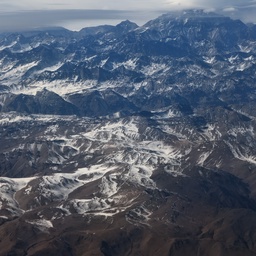 Snow-covered mountain range under a bright sky.