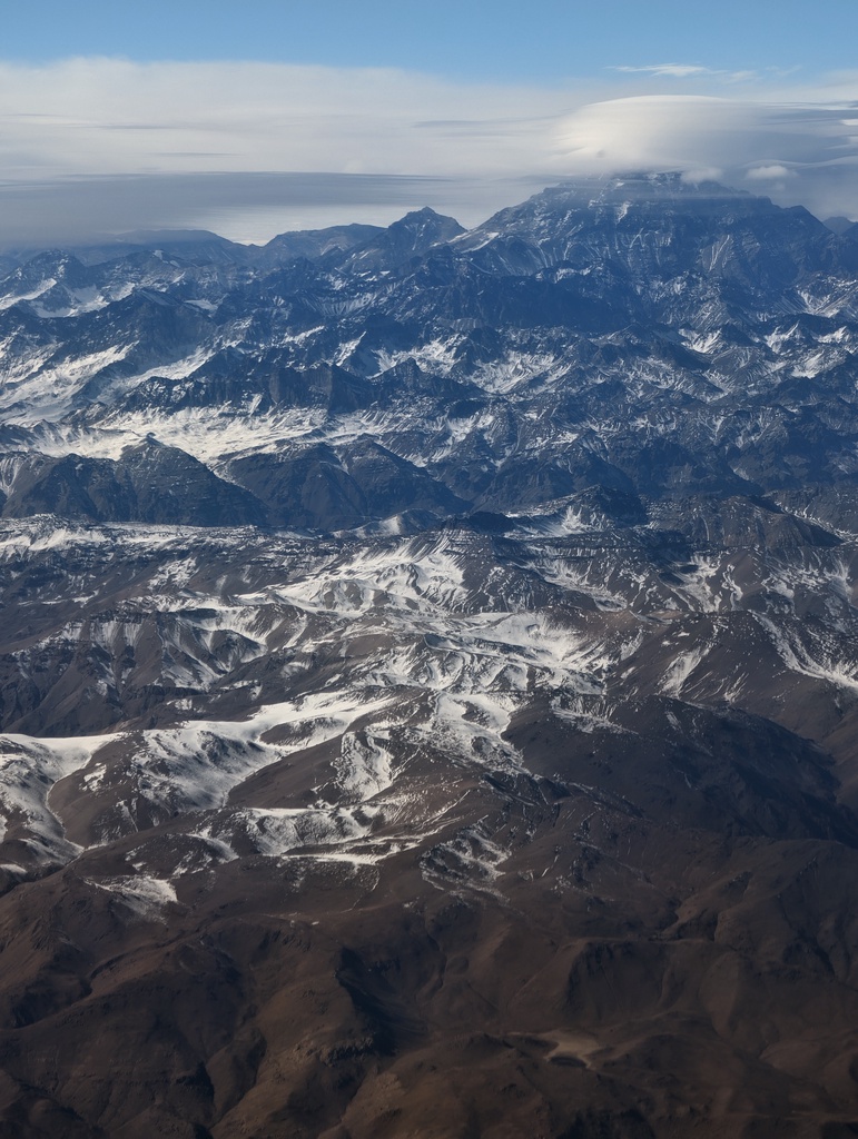 Snow-covered mountain range under a bright sky.