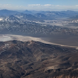 An aerial view of a vast, arid mountain range.