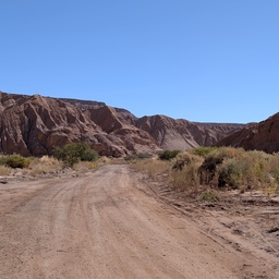 A dirt road winding through a desert landscape.